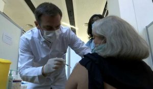 En blouse, Olivier Véran vaccine lui-même une patiente contre le Covid