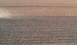 Vue aérienne par drone d'un tracteur dans un champ