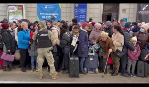 Ukrainiens et immigrés à Lviv attendent un train pour la Pologne