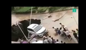 Ces Chinois ont uni leurs efforts pour sauver cette voiture d'un trou gigantesque en pleine route