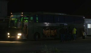 Des personnes évacuées du Soudan montent dans un bus à leur arrivée à Chypre