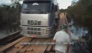 Un camion trop lourd bascule sur un pont en bois