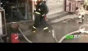 Un pompier chinois transporte une bouteille de gaz en feu