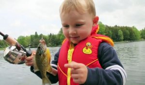 Cet enfant pêche son premier poisson et en est très content