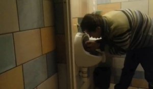 Un polonais bourré boit dans un urinoir