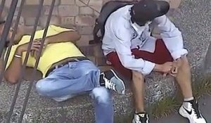 Un voleur fait les poches d'un gars endormi dans la rue