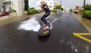 Il surfe dans les rue de sa ville après un orage qui a tout inondé.