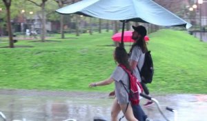 Protéger des passants de la pluie avec un parapluie géant! Magique...