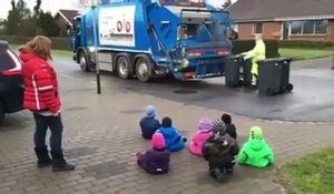 Des enfants regardent des éboueurs