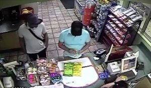Un malfaiteur installe un skimmer sur un lecteur de carte bancaire