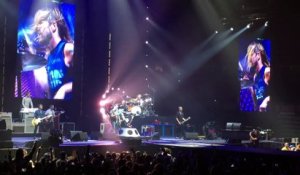 Un fan monte sur scène chanter "Tom Sawyer" de Rush lors d'un concert des Foo Fighters