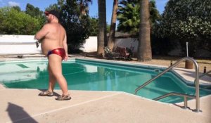 Un homme danse au bord d'une piscine en maillot de bain