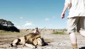Un couple de chasseurs pose avec un lion mort