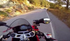 Un motard en duel une BMW sur une route sinueuse