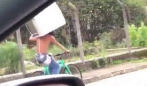 Un homme transporte un frigo sur son vélo