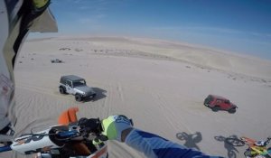 Une moto atterrit sur une Jeep dans le désert