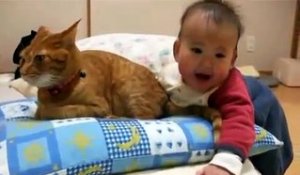 Un bébé qui joue avec la queue de son chat !