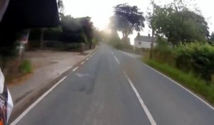Ce motard chute et se prend un panneau en bord de route