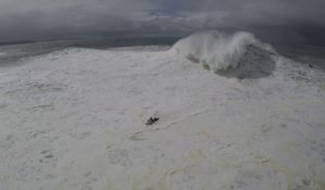 Double chute pour ce surfeur prenant une vague géante à Nazaré, secouru par un jet ski qui va aussi chuter.