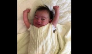 Un bébé lève les bras en l'air