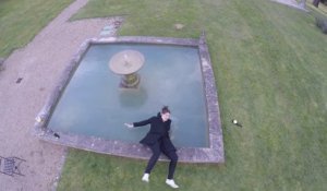 Une femme chute dans une fontaine en regardant un drone