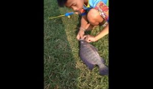 Ce gamin attrape un beau poisson avec son jouet canne à peche...