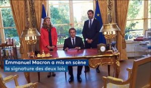 Macron signe une loi face aux caméras, dans une mise en scène à l'américaine