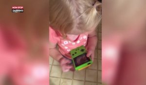 Elle essaie de jouer avec une Gameboy mais, trop jeune, elle ne sait pas comment marchent des boutons (Vidéo)