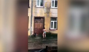 Une femme se lave sous la pluie !