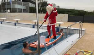 Le père Noël arrive en paddle à la piscine