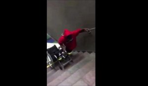 Cet handicapé doit porter son fauteuil roulant pour monter les escaliers du métro