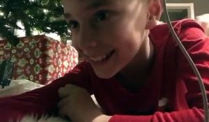 Un enfant place une caméra sous le sapin pour filmer le Père Noël