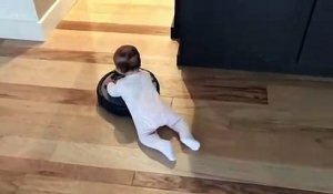 Un bébé s'amuse sur un aspirateur roomba... Trop mignon