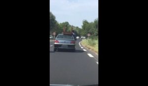 Ils transportent une table non attachée sur le toit d'une voiture en pleine autoroute