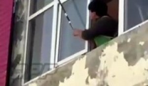 Un homme tente de détruire un nid de guêpes depuis sa fenêtre