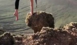 Elle se met en équilibre sur les mains au bord du vide sur un petit rocher... risqué