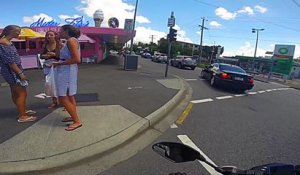 Un motard distrait par 3 jolies filles s'encastre dans une voiture