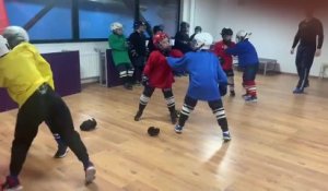 Des enfants s'entrainent au combat pendant un cours de hockey sur glace