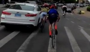 Deux cyclistes s'accrochent à une voiture