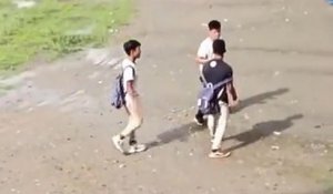 Un enfant calme rapidement deux élèves qui veulent se battre