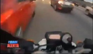 Un motard fonce entre les voitures dans un bouchon
