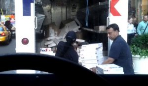 Des employés FedEx lancent des colis