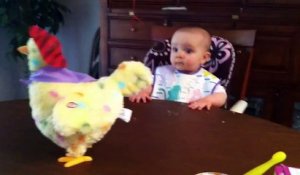 Un bébé surpris par une poule en peluche qui pond des oeufs