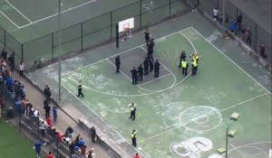 Un Fou coincé sur un panier de basket veut frapper les policiers avec un marteau
