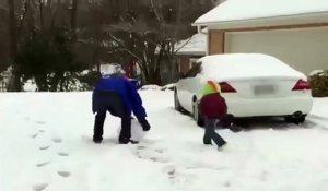 Un papa lance une boule de neige à son enfant
