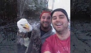 2 canadiens font un Selfie avec un aigle qu'ils viennent de libérer