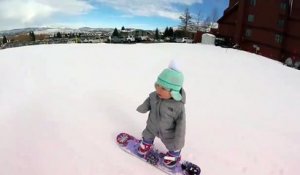 Une petite fille âgée de 1 an fait du snowboard