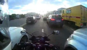 Deux voitures bloquent un motard dans un embouteillage