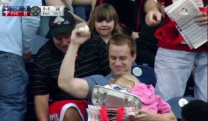 Papa attrape une balle de Baseball avec un bébé dans les mains en plein match dans les tribunes