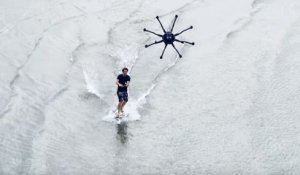 Un homme surfe sur l'eau tracté par un drone super puissant